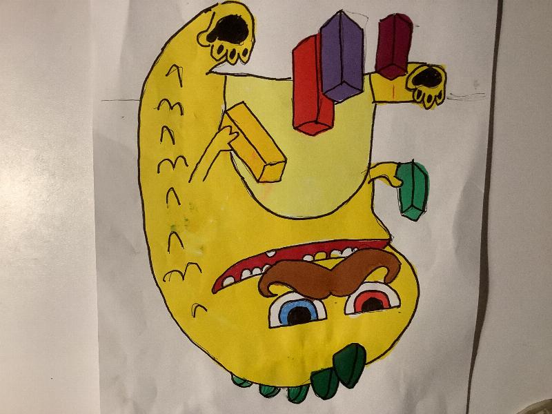 Et gult monster med mustach som leger med klosser